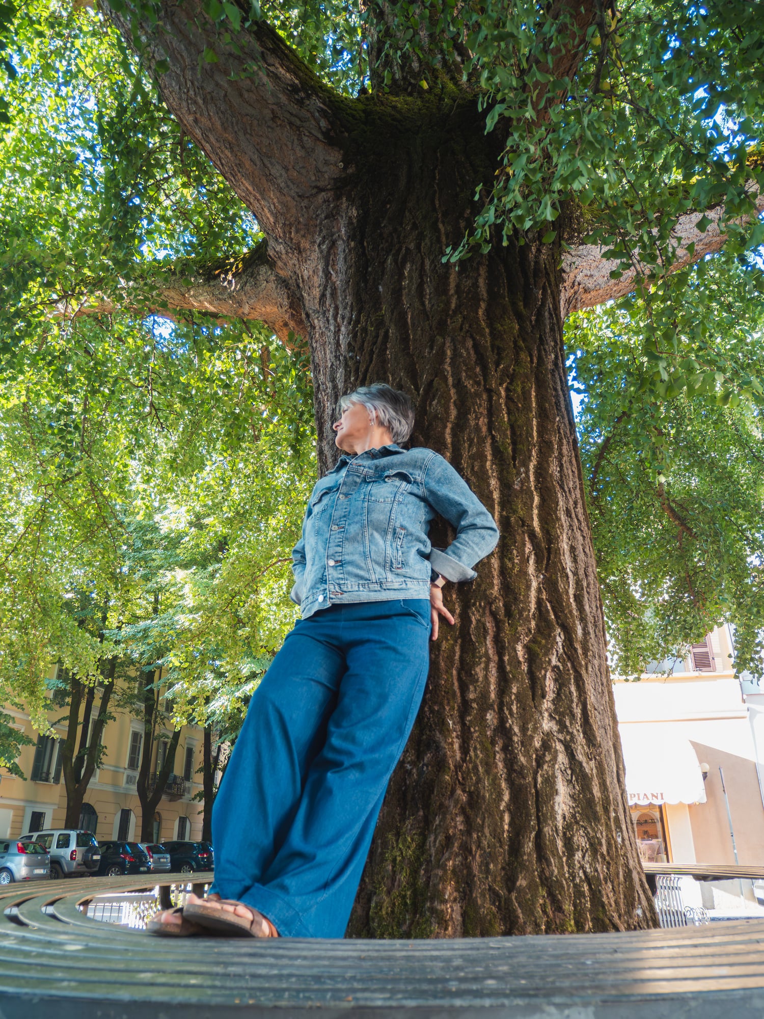 Woman standing by an oak tree at sunrise, symbolizing grounding and healing the father wound.
